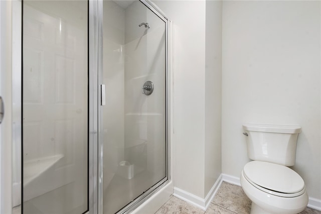 bathroom featuring a shower with door, toilet, and tile patterned floors