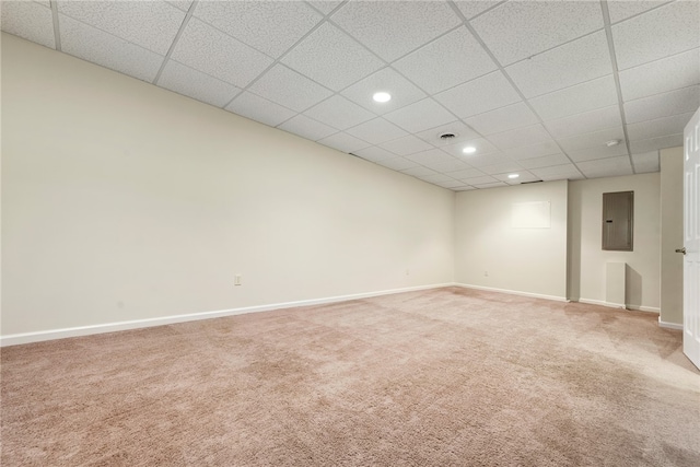 spare room with a drop ceiling, electric panel, and carpet flooring