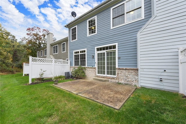 rear view of property featuring a patio area, central AC, and a yard