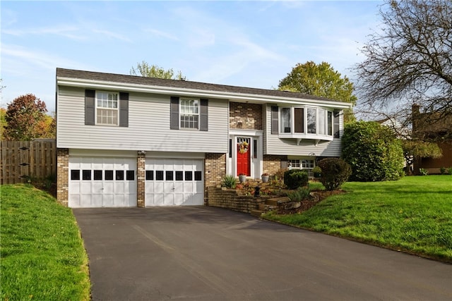 bi-level home featuring a garage and a front lawn