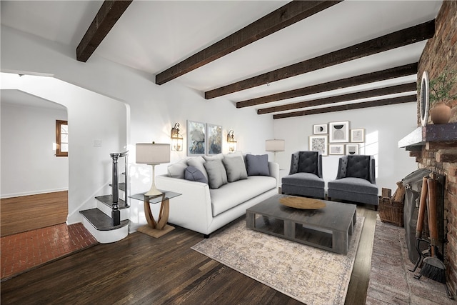 living room with a fireplace, beam ceiling, and dark hardwood / wood-style flooring