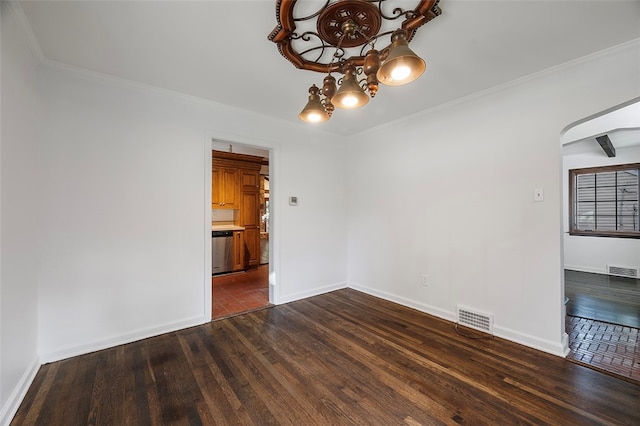 empty room featuring dark wood-type flooring and crown molding