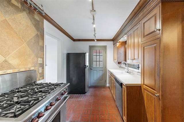 kitchen featuring sink, track lighting, stainless steel appliances, crown molding, and decorative backsplash