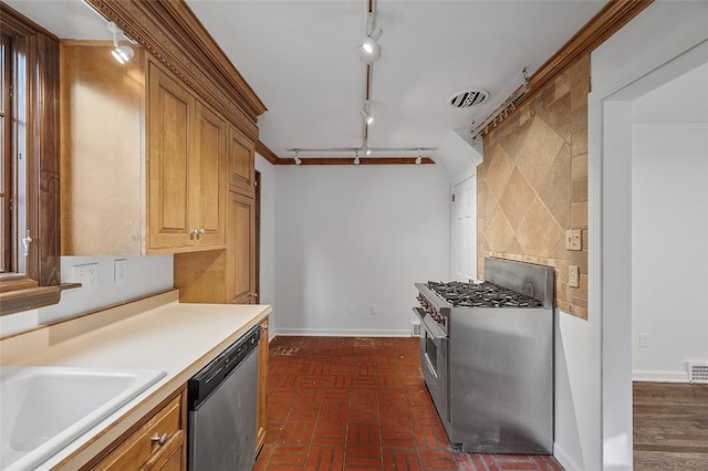 kitchen with ornamental molding, rail lighting, sink, and stainless steel appliances