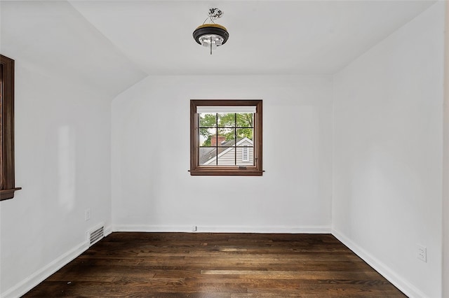 unfurnished room featuring dark wood-type flooring and lofted ceiling