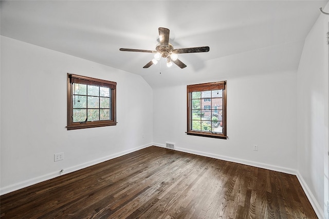 spare room featuring vaulted ceiling, a healthy amount of sunlight, ceiling fan, and hardwood / wood-style floors