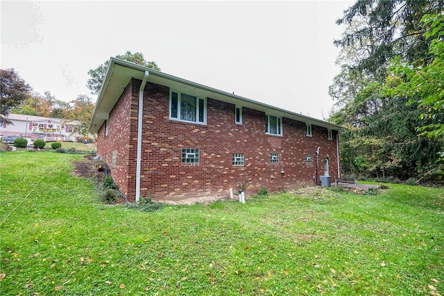 view of side of property featuring central AC and a yard