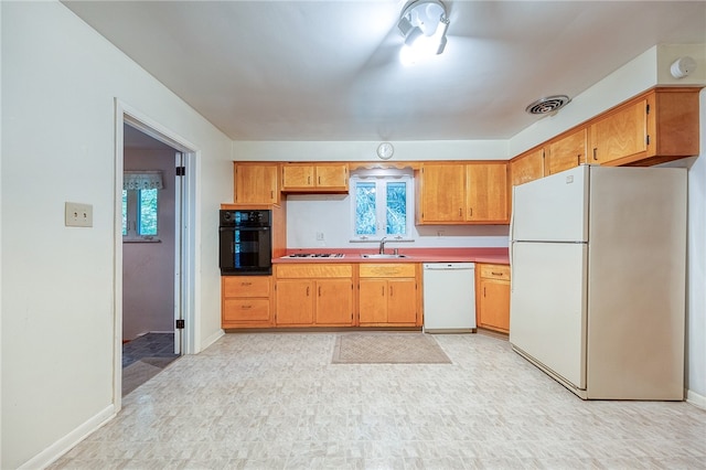 kitchen with sink, plenty of natural light, and white appliances