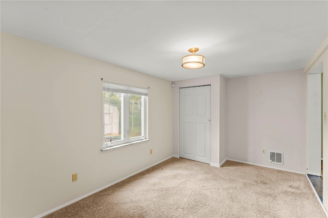 unfurnished room featuring light colored carpet