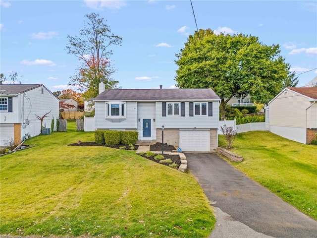 raised ranch with a garage and a front lawn