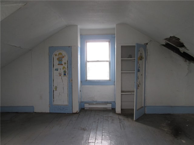 additional living space with a baseboard radiator, vaulted ceiling, and hardwood / wood-style flooring