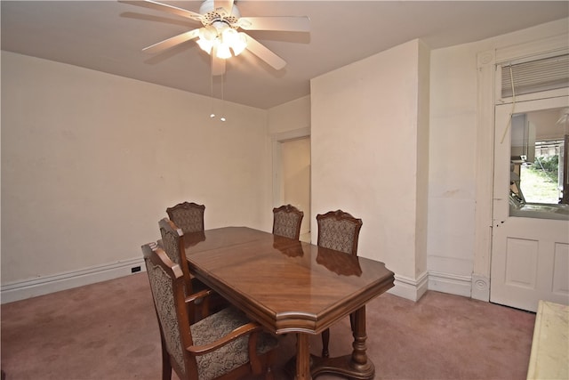 carpeted dining area with ceiling fan