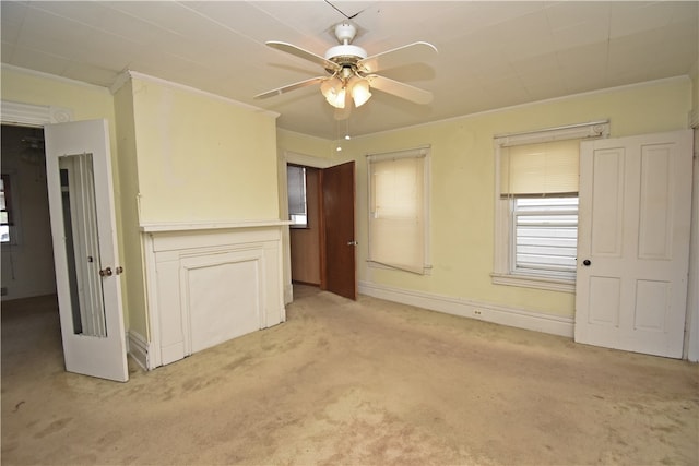 carpeted empty room with crown molding and ceiling fan