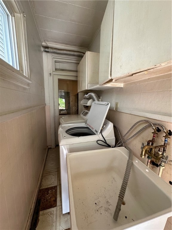 clothes washing area with cabinets and washer and clothes dryer