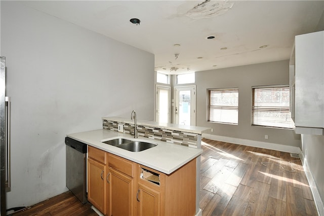 kitchen with sink, kitchen peninsula, stainless steel appliances, dark hardwood / wood-style flooring, and decorative backsplash