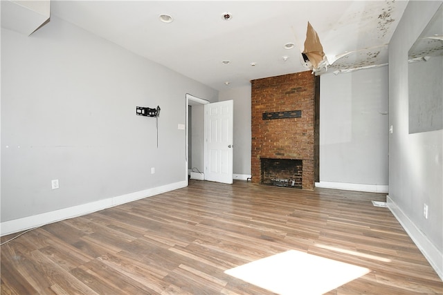 unfurnished living room featuring a fireplace and hardwood / wood-style floors