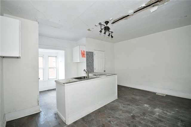 kitchen featuring sink, dark hardwood / wood-style flooring, and white cabinetry