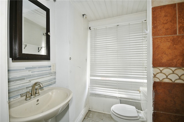 bathroom featuring sink, toilet, and tasteful backsplash