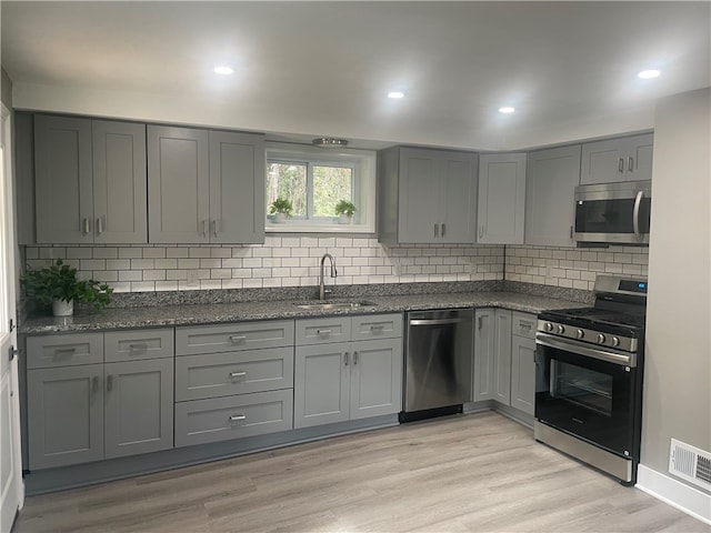 kitchen featuring gray cabinetry, light hardwood / wood-style floors, and stainless steel appliances