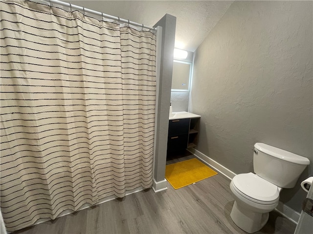 bathroom featuring vanity, toilet, a textured ceiling, walk in shower, and hardwood / wood-style floors