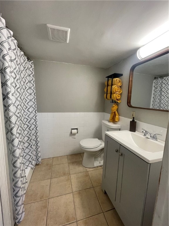 bathroom featuring tile patterned flooring, toilet, tile walls, vanity, and a shower with curtain