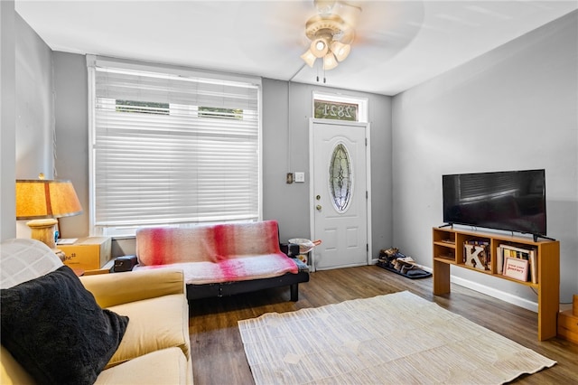 living room featuring dark wood-type flooring and ceiling fan