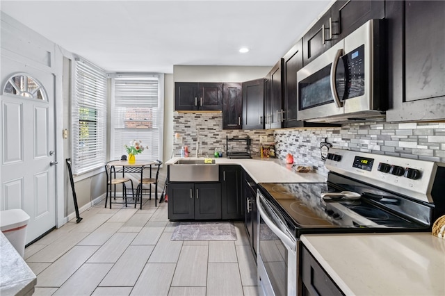 kitchen featuring dark brown cabinetry, appliances with stainless steel finishes, backsplash, and sink