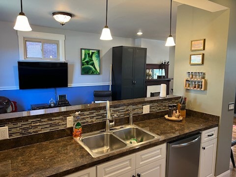 kitchen with stainless steel dishwasher, pendant lighting, and white cabinetry