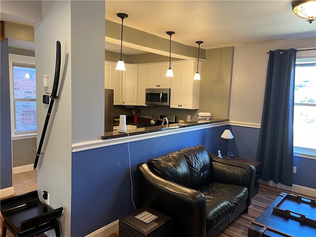 kitchen with white cabinets, decorative light fixtures, dark hardwood / wood-style flooring, and appliances with stainless steel finishes