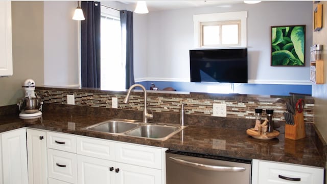 kitchen featuring dishwasher, sink, white cabinets, and hanging light fixtures