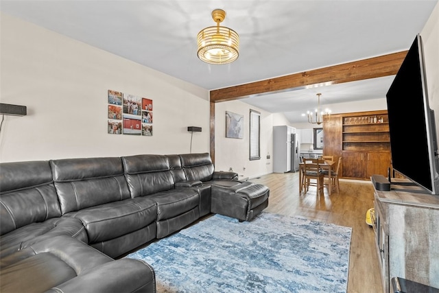 living room featuring a notable chandelier, beam ceiling, and light hardwood / wood-style flooring