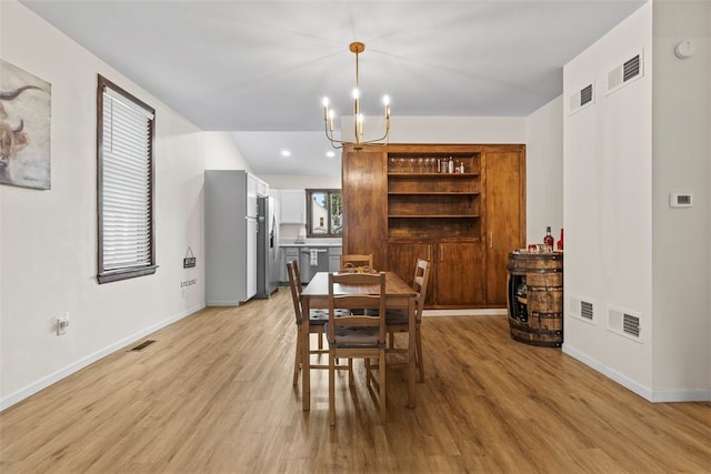 dining room featuring an inviting chandelier and light wood-type flooring