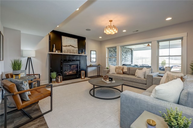 living room featuring hardwood / wood-style flooring, a fireplace, and a chandelier