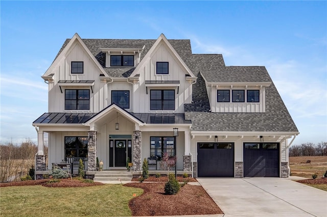 modern inspired farmhouse featuring a front lawn, covered porch, and a garage