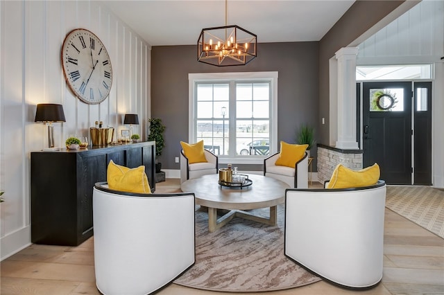 interior space featuring an inviting chandelier, decorative columns, plenty of natural light, and light hardwood / wood-style floors