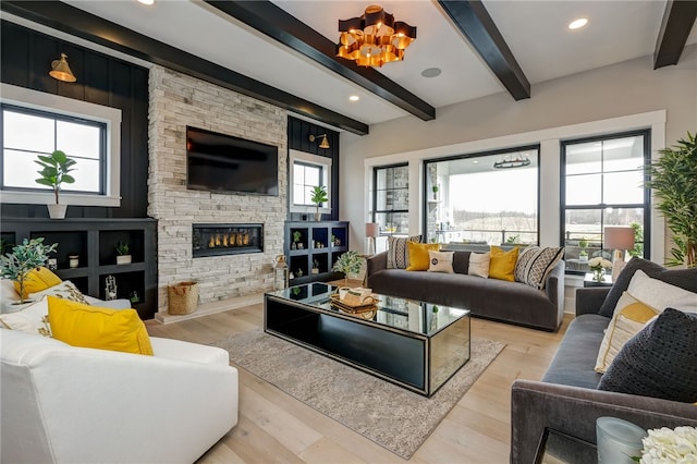 living room with beamed ceiling, a wealth of natural light, and light hardwood / wood-style floors