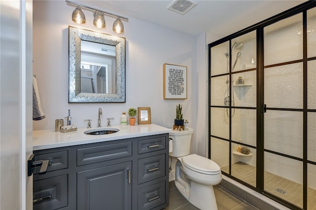 bathroom featuring tile patterned flooring, a shower with shower door, vanity, and toilet