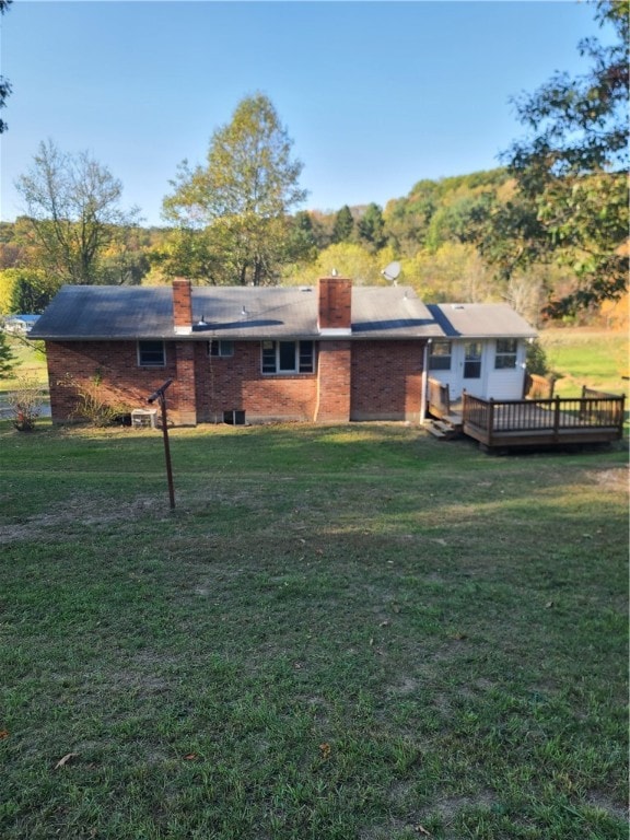 back of house featuring a wooden deck and a lawn