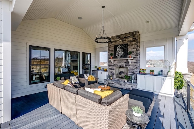 wooden terrace with an outdoor living space with a fireplace