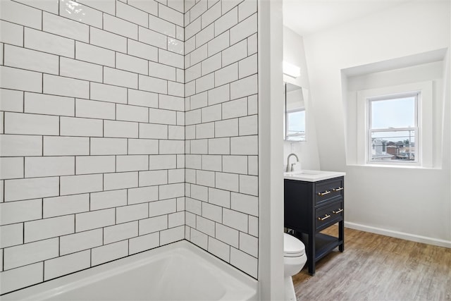 full bathroom with vanity, toilet, wood-type flooring, and tiled shower / bath combo