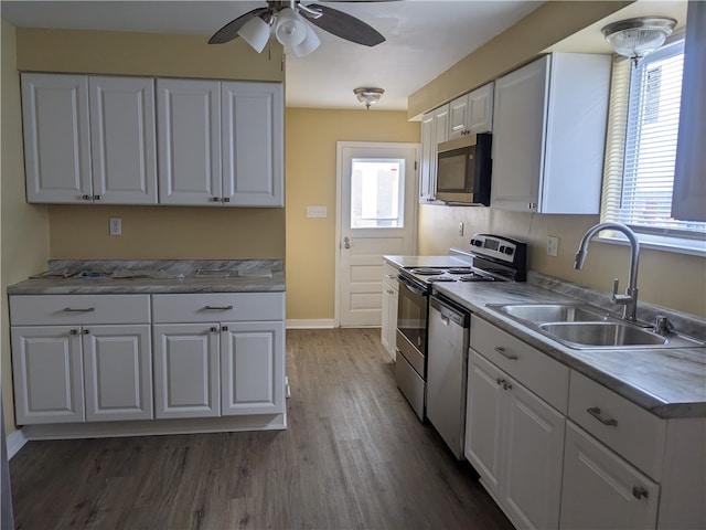 kitchen with ceiling fan, white cabinets, sink, dark hardwood / wood-style flooring, and appliances with stainless steel finishes