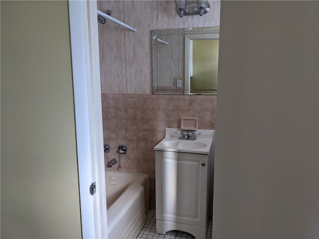 bathroom featuring shower / bathing tub combination, tile patterned floors, vanity, and tile walls