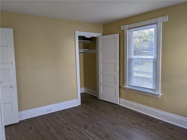 unfurnished bedroom featuring a closet and dark hardwood / wood-style flooring