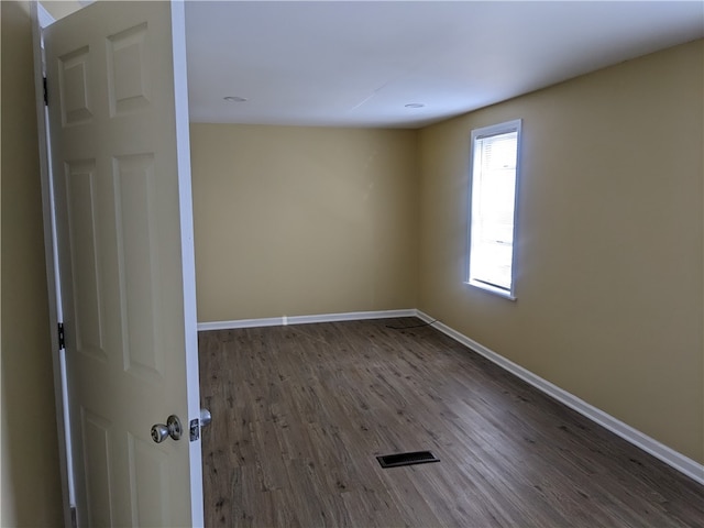 spare room featuring dark wood-type flooring