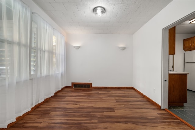 empty room with dark hardwood / wood-style flooring