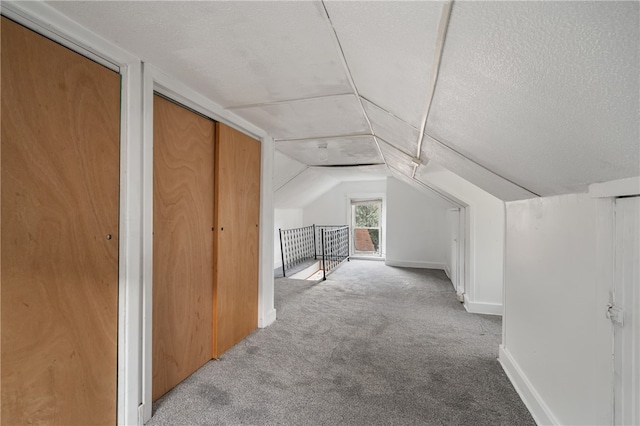 bonus room featuring light carpet, lofted ceiling, and a textured ceiling