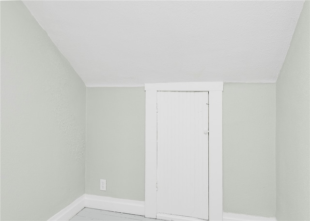 unfurnished room with vaulted ceiling