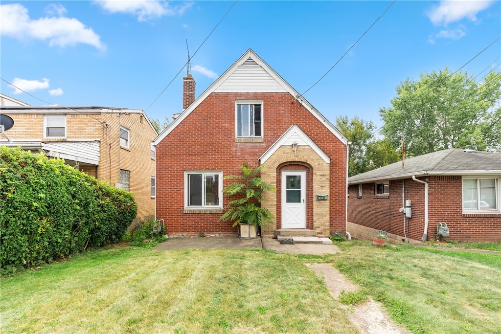 tudor-style house with a front yard