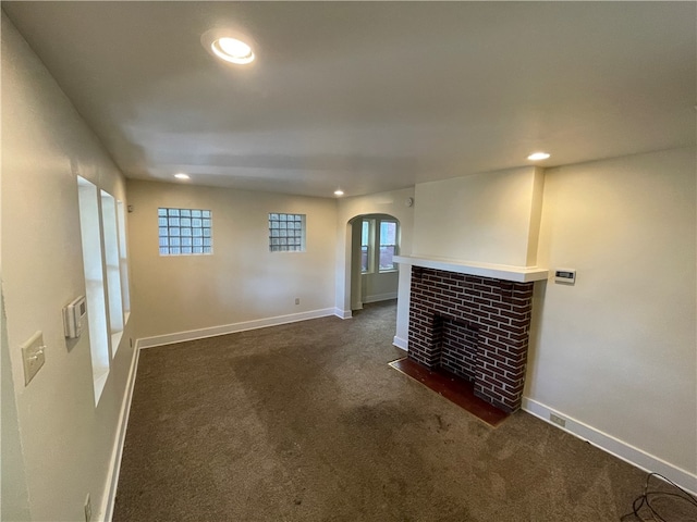 unfurnished living room featuring dark carpet