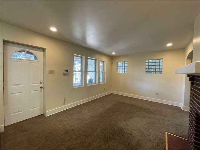 carpeted entryway with a brick fireplace